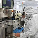 Engineer inspecting semiconductor equipment in an Indian cleanroom