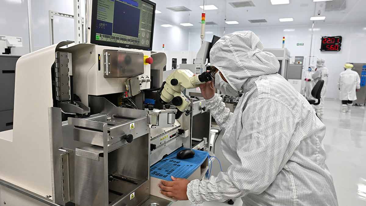 Engineer inspecting semiconductor equipment in an Indian cleanroom