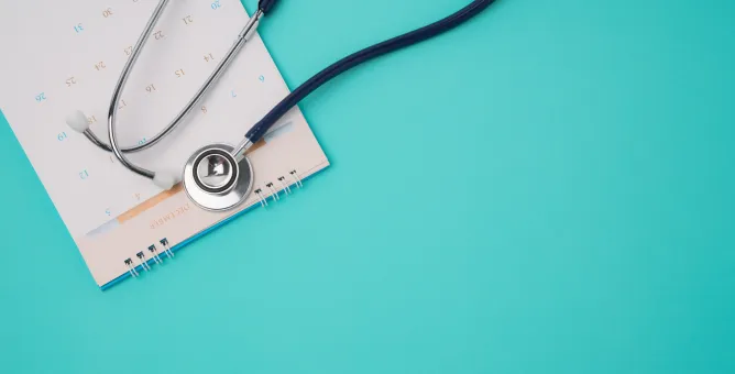 Stethoscope beside a medical appointment notebook